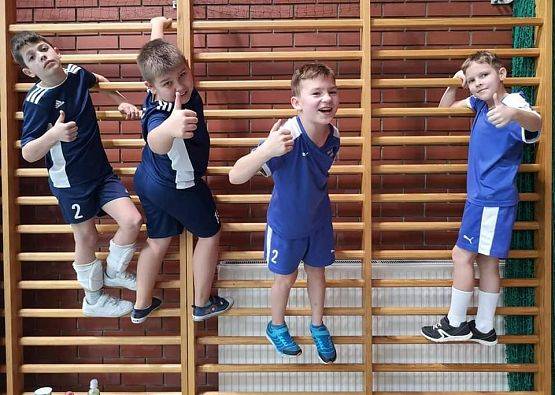 Chłopcy na drabinkach gimnastycznych na hali sportowej.