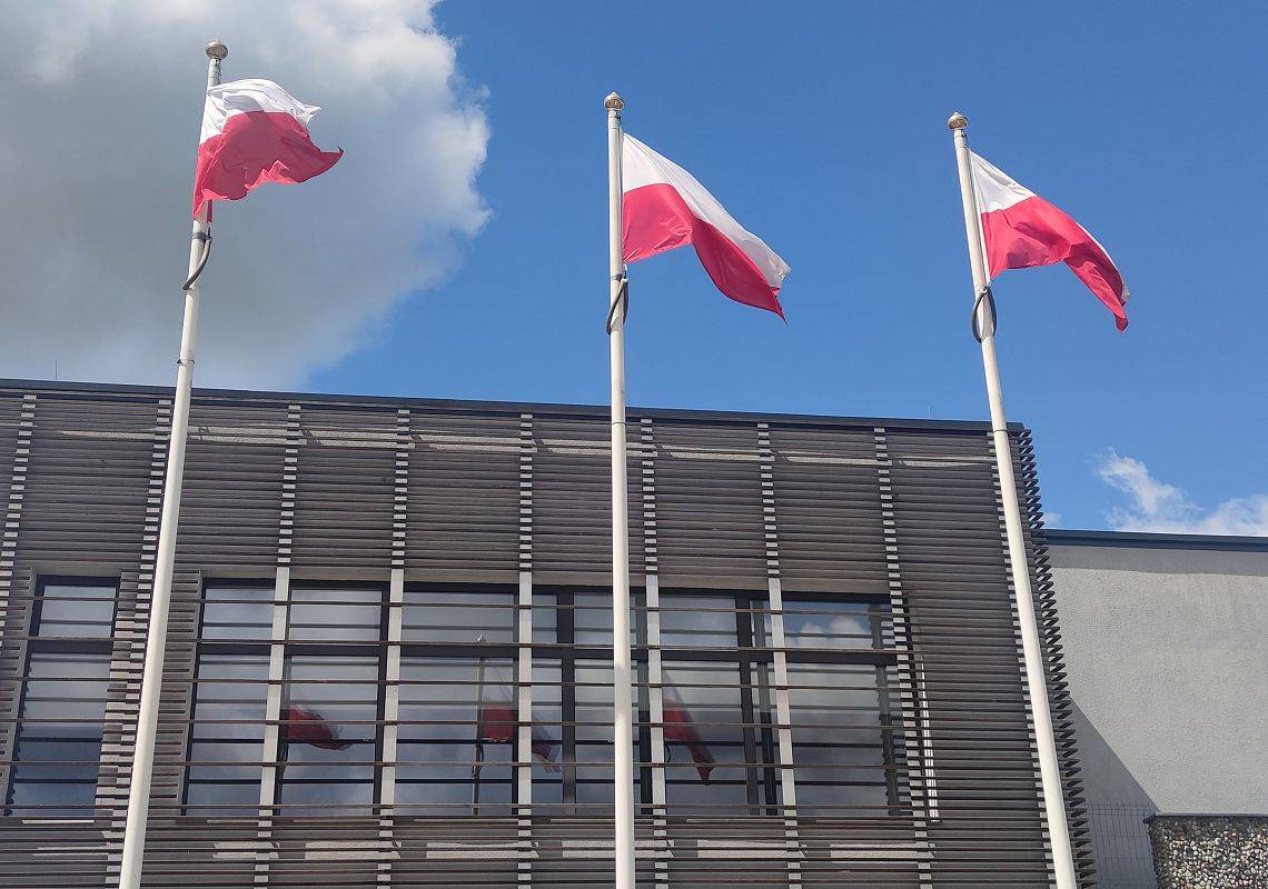 Flagi na masztach, w tle budynek Urzędu Gminy w Nowej Wsi Lęborskiej
