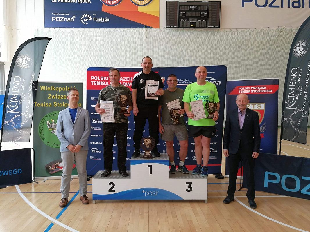 Zawodnicy stoją na podium.