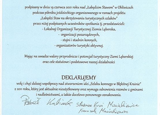 Na niebieskim tle treść listu intencyjnego z podpisami osób.