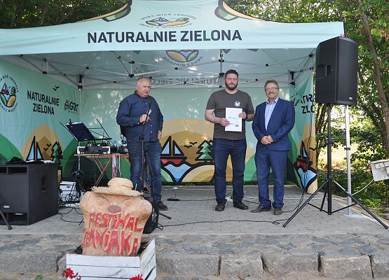 Na scenie podczas festiwalu od lewej: Prowadzący, Pełniący Funkcję Wójta Gminy, Wice Starosta Lęborski.