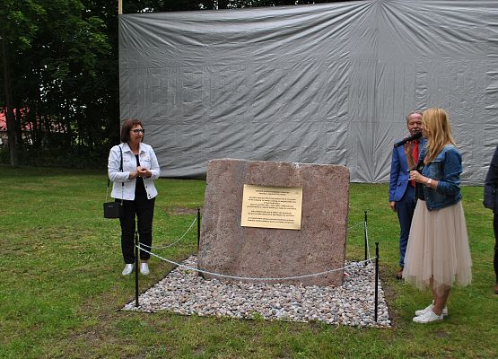 Zaproszeni goście przy kamiennej tablicy.