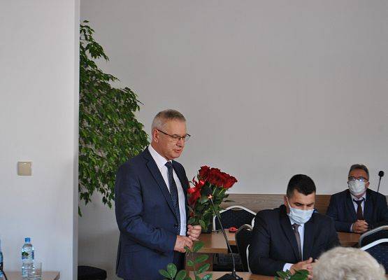 Wójt Gminy Zdzisław Chojnacki przemawia, w ręku trzyma z bukiet czerwonych róż.