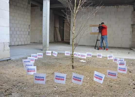 Stan surowy budowanego budynku hospicjum - widok wewnątrz obiektu. Na drugim planie operator kamery filmujący wnętrze obiektu. Fot. Marcin Kapela, Dziennik Bałtycki