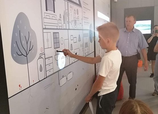 Chłopiec przy tablicy interaktywnej w jednej z sal wystawowych muzeum.