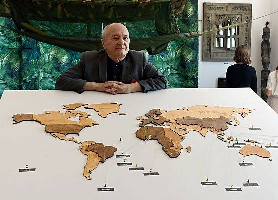 Jacek Pałkiewicz przy mapie z świata.