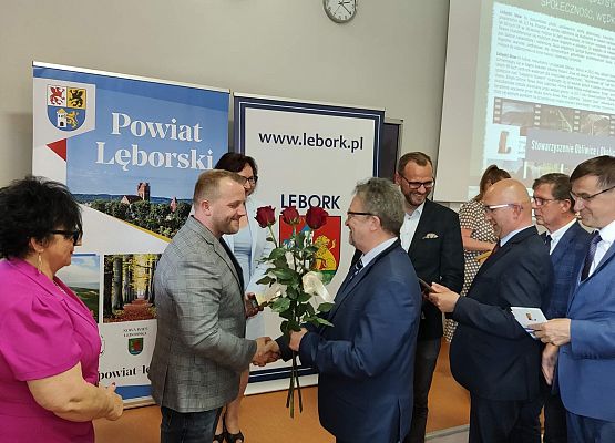 Zastępca Starosty Lęborskiego wręcza kwiaty Wiceprezesowi zarządu stowarzyszenia.