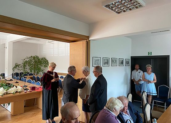 Wójty dekoruje jubilatkę medalem.