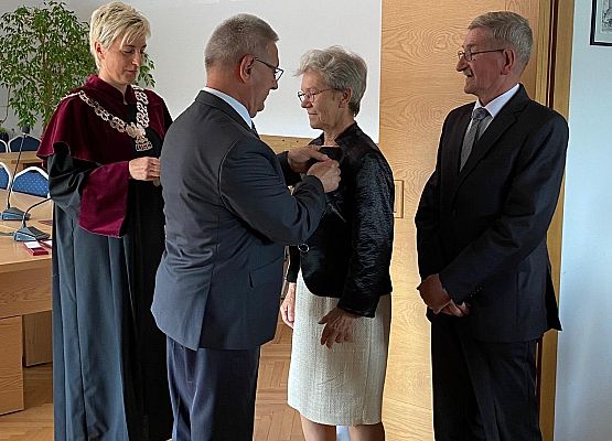 Wójty dekoruje jubilatkę medalem.