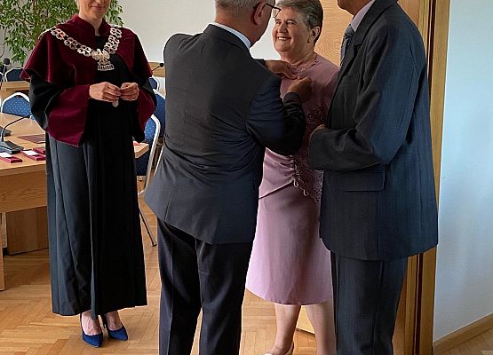 Wójty dekoruje jubilatkę medalem.