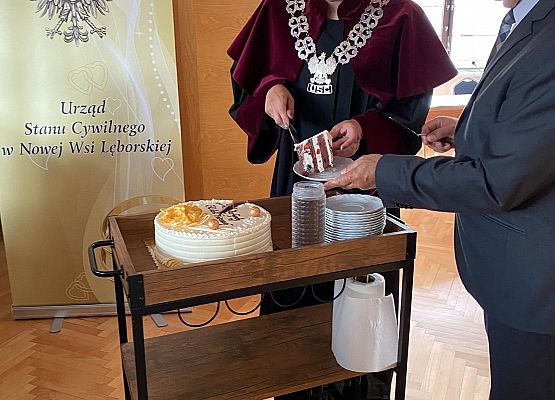 Wójt i kierownik USC częstują tortem.