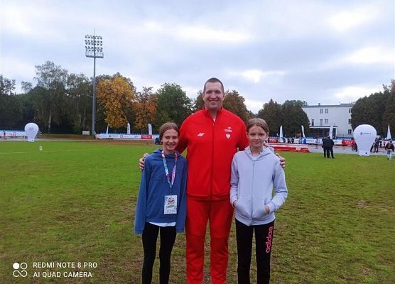 Zawodniczki z mistrzem olimpijskim Wojciechem Nowickim na stadionie.