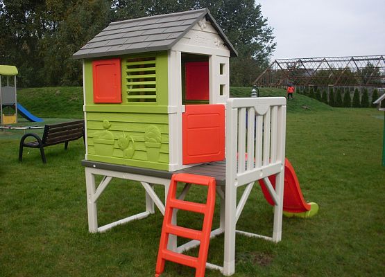 Domek dla dzieci ustawiony na placu zabaw.