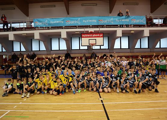 Zdjęcie grupowe uczestników turnieju na hali sportowej.