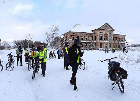 Uczestnicy rowerowej trasy rajdu w zimowej scenerii.