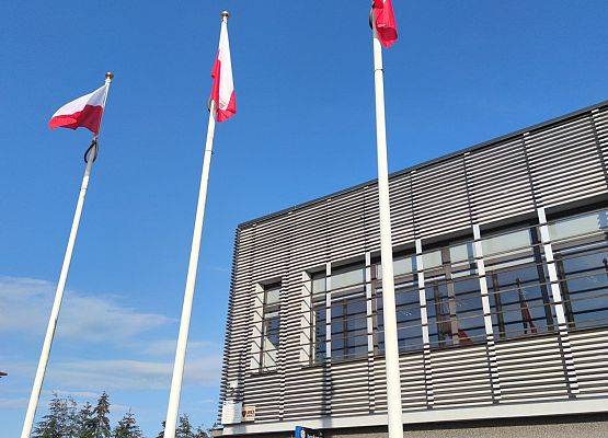 Białoczerwone flagi na masztach przed budynkiem Urzędu Gminy w Nowej Wsi Lęborskiej.
