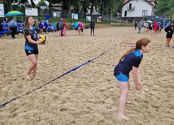 Dwie dziewczyny w trakcie gry w siatkową piłkę plażową.