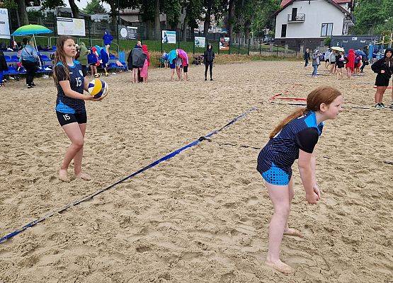 Dwie dziewczyny w trakcie gry w siatkową  piłkę plażową.