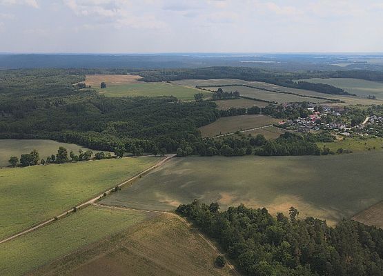 Tereny inwestycyjne w obrębie miejscowości Małoszyce - zdjęcie z lotu ptaka, w tle miejscowość Małoszyce