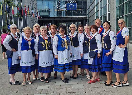 Kobiety w regionalnych strojach pozują do zdjęcia przed budynkiem Parlamentu Europejskiego.