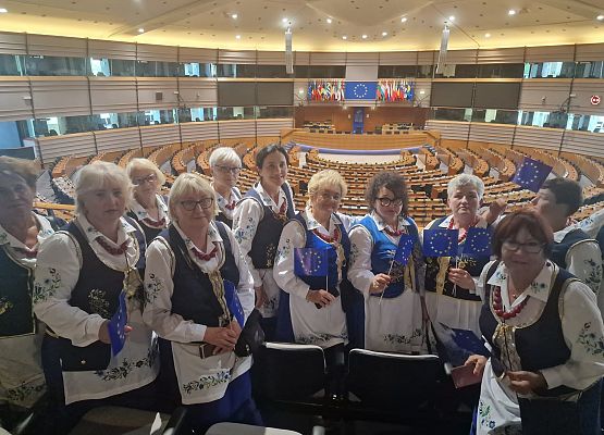 Kobiety w regionalnych strojach pozują do zdjęcia w sali obrad Parlamentu Europejskiego.