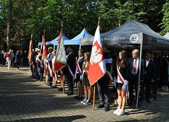 Poczty sztandarowe lokalnych szkół i organizacji stoją wzdłuż alei na cmentarzu w Krępie Kaszubskiej.