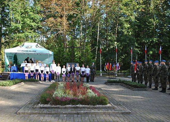 Młodzież szkolna (chłopcy i dziewczęta) ze szkoły podstawowej w Garczegorzu występują przed publicznością podczas uroczystości.