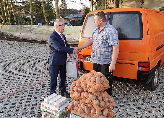 Wójt wręcza mężczyźnie (rolnikowi) torebkę.