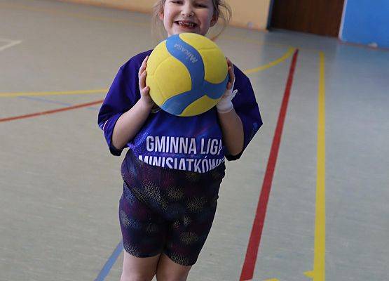 Dziewczynka trzyma piłkę siatkową.