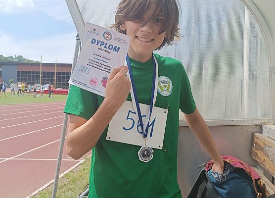 Zawodnik z dyplomem w ręku.