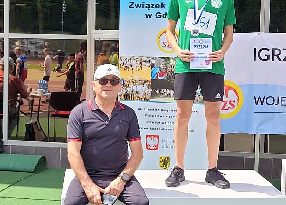 Zawodnik z ternerm pozują do zdjęcia.