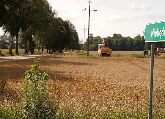Znak drogowy, w tle droga do Niebędzina.