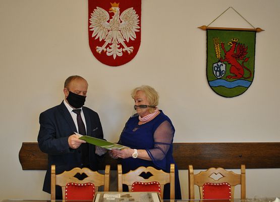 Gabinet wójta gminy. Wójt wręczający podziękowania pielęgniarce szkolnej.