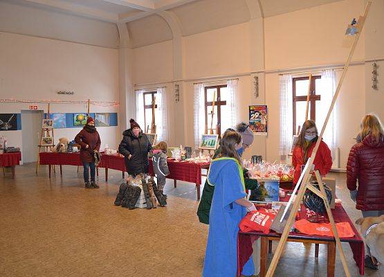 Sala w budynku ośrodka kultury, a w niej ustawione stoiska kiermaszowe.