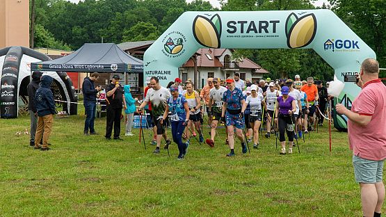 Zawodnicy kilka sekund po starcie biegu. w tle brama startowa i kibice.