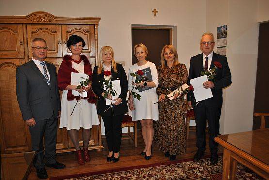 Zdjęcie grupowe w gabinecie wójta, od strony lewej stoją: Wójt Gminy Nowa Wieś Lęborska oraz trzymający w dłoniach dyplomy i róże dyrektorzy placówek oświatowych: ZS Garczegorze, SP Leśnice, SP Redkowice, Przedszkole NWL, ZS Łebień