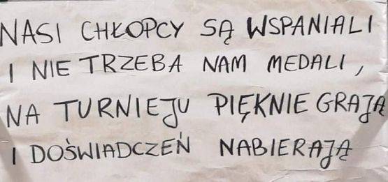 Treść hasła dla kibiców: "Nasi chłopcy są wspaniali i nie trzeba im medali, na turnieju pięknie grają i doświadczeń nabierają"