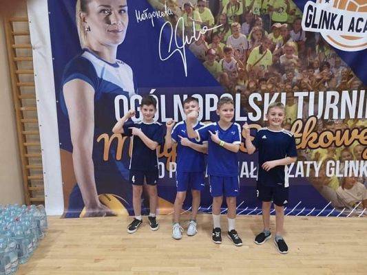 Czterech uśmiechniętych chłopców pozuje do zdjęcia.