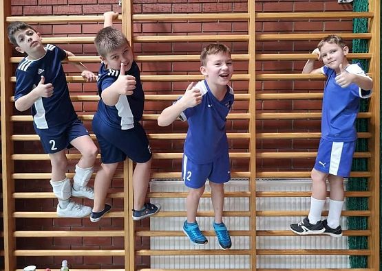 Chłopcy na drabinkach gimnastycznych na hali sportowej.