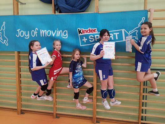 Dziewczęta na drabinkach gimnastycznych na hali sportowej.