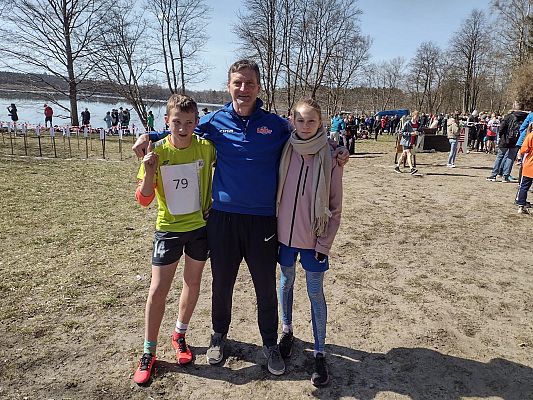 Zawodnicy Konrad i Michalina pozują do zdjęcia z trenerem.