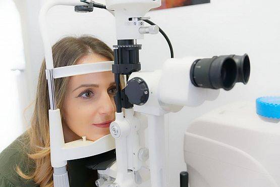 Kobieta w trakcie badania okulistycznego. grafika