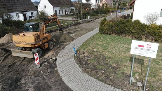 Koparka pracująca na drodze. grafika