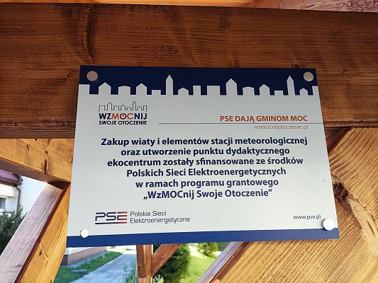 Tabliczka informacyjna nt. realizacji projektu zamontowana pod wiatą.