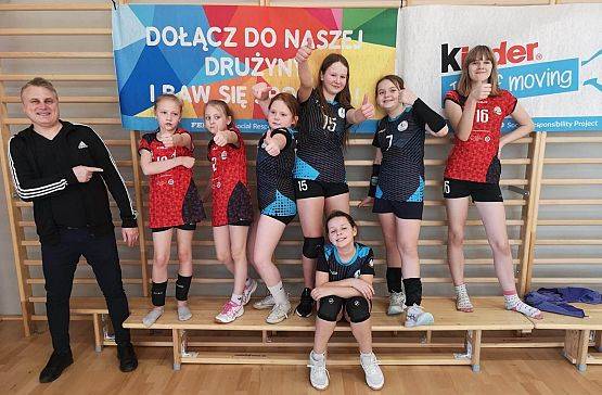 Zawodniczki z trenerem pozują do zdjęcia po turnieju.