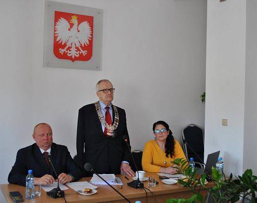Roman Downar Zapolski - wiceprzewodniczący rady, Zdzisław Korda - przewodniczący rady, Urszula Sech - wiceprzewodnicząca rady siedzą przy stole na tle godła.