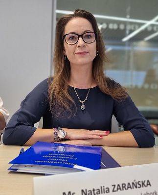 Kobieta siedzi przy stole podczas spotkania.