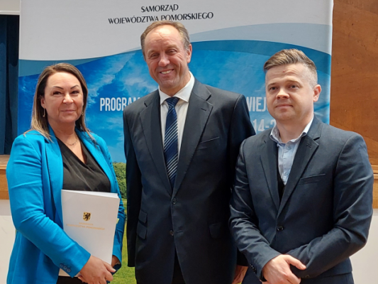 Przedstwiciele stowarzyszenia po podpisaniu umowy pozują do zdjęcia z marszałkiem wojwództwa pomorskiego.